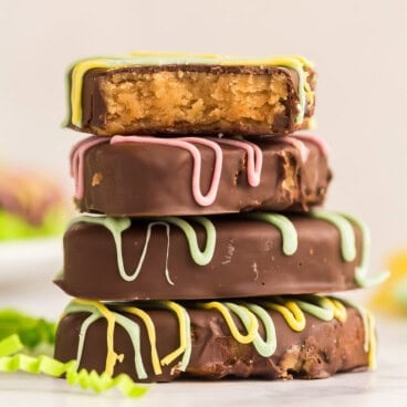 square image of a stack of four reeses peanut butter eggs with chocolate drizzle.