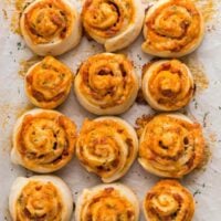 close up overhead image of baked pizza rolls on pan