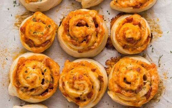 close up overhead image of baked pizza rolls on pan