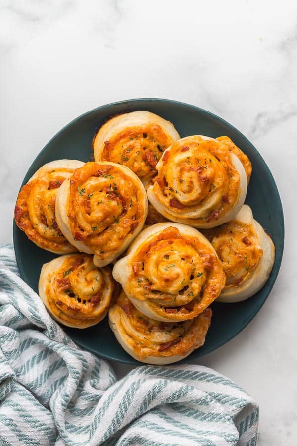 overhead image of pizza rolls on green plate