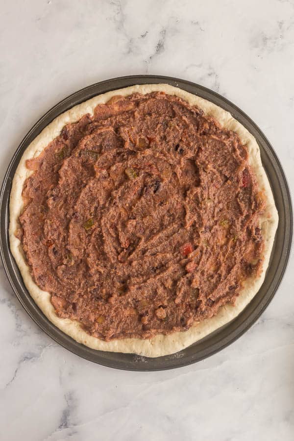 taco pizza sauce spread on pizza dough