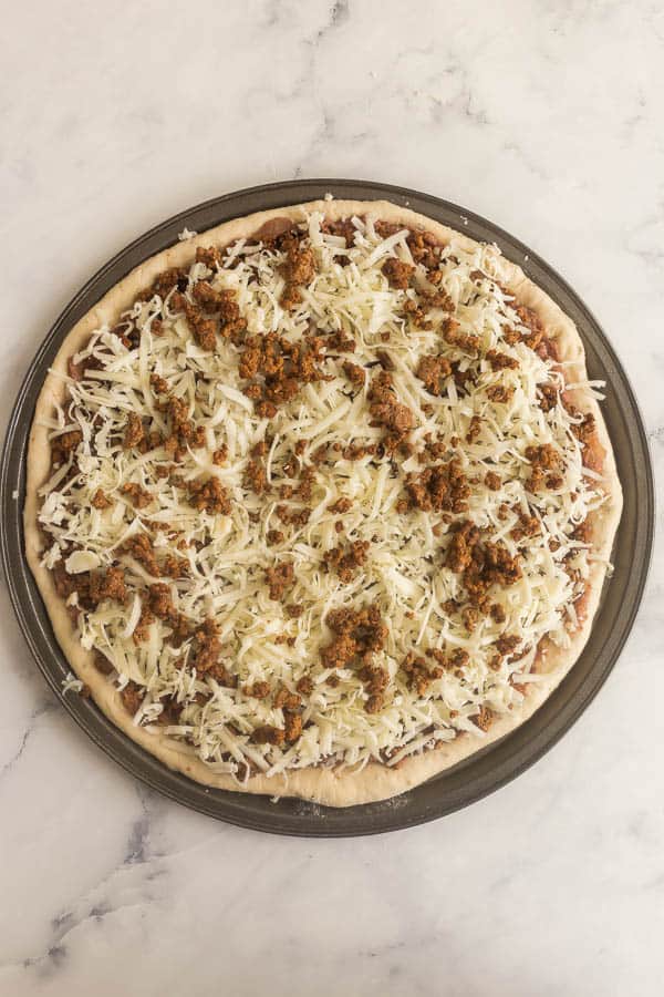 pizza dough topped with taco pizza sauce ground beef and cheese