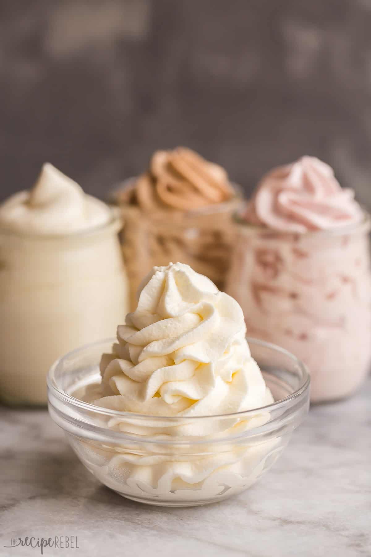 A simple homemade Whipped Cream recipe that is perfect every time, with heavy whipping cream, powdered sugar and vanilla. Tons of tips on how to make whipped cream, flavor variations and a step by step video! #dessert #recipe #whippedcream | whipped cream recipes | whipping cream | whipped topping | homemade whipped cream | how to whip cream | strawberry whipped cream | chocolate whipped cream | easy dessert recipes | easy recipes how to make whipped cream in glass bowl with three flavors behind.