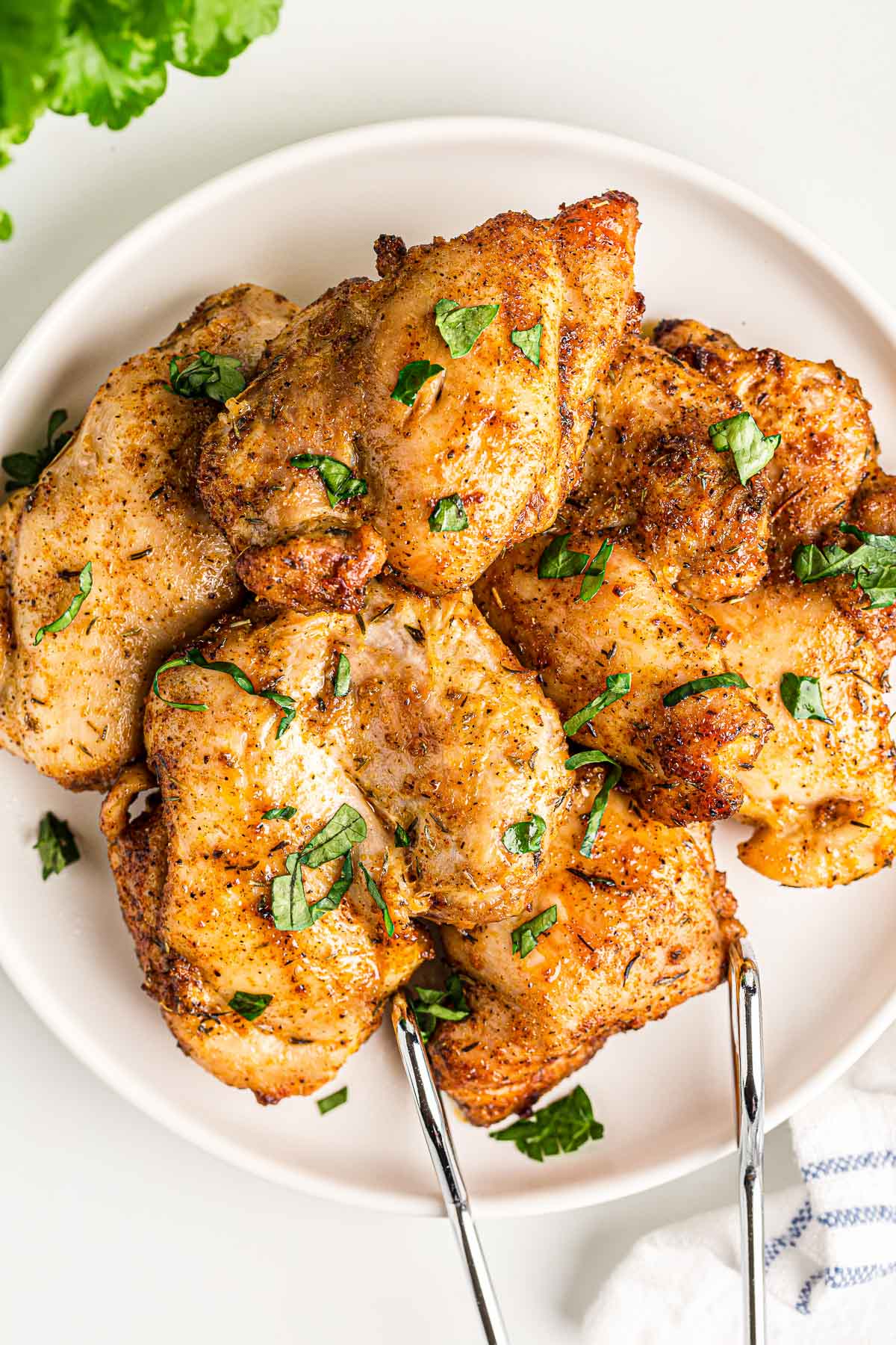 air fryer boneless chicken thighs on white plate.