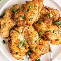 overhead image of air fryer chicken thighs on white plate