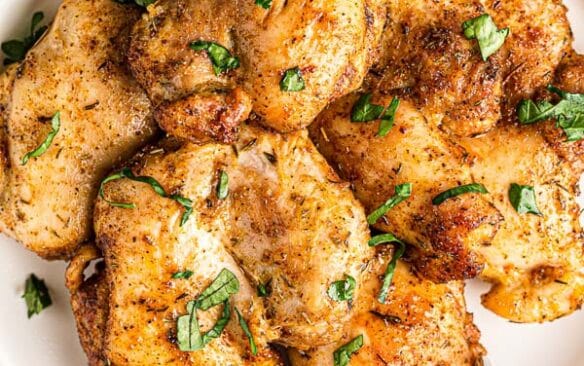 overhead image of air fryer chicken thighs on white plate
