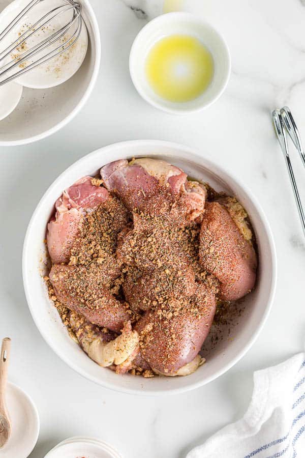 boneless chicken thighs in bowl with spices