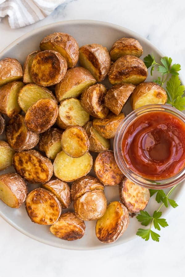 overhead image of crispy air fryer potatoes on plate with ketchup