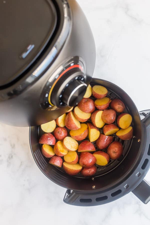 uncooked potatoes in air fryer basket