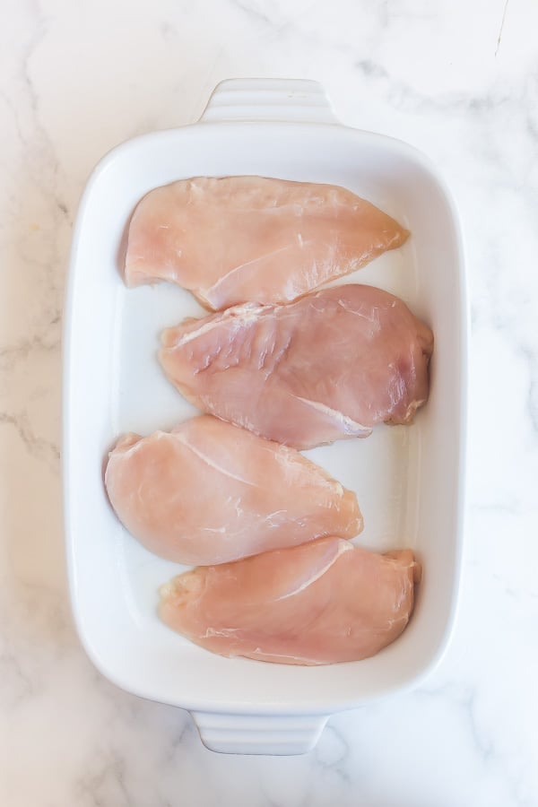 uncooked chicken breasts in baking dish