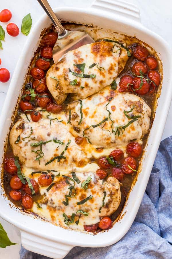 metal ladle scooping chicken breast out of baking dish