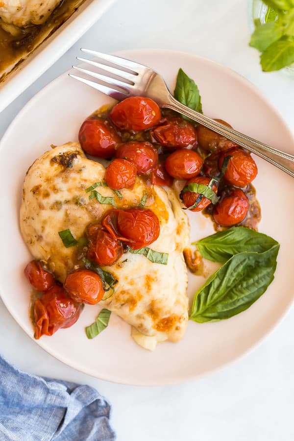 caprese chicken on plate with roasted cherry tomatoes