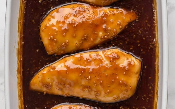 overhead image of honey garlic chicken breasts in baking dish