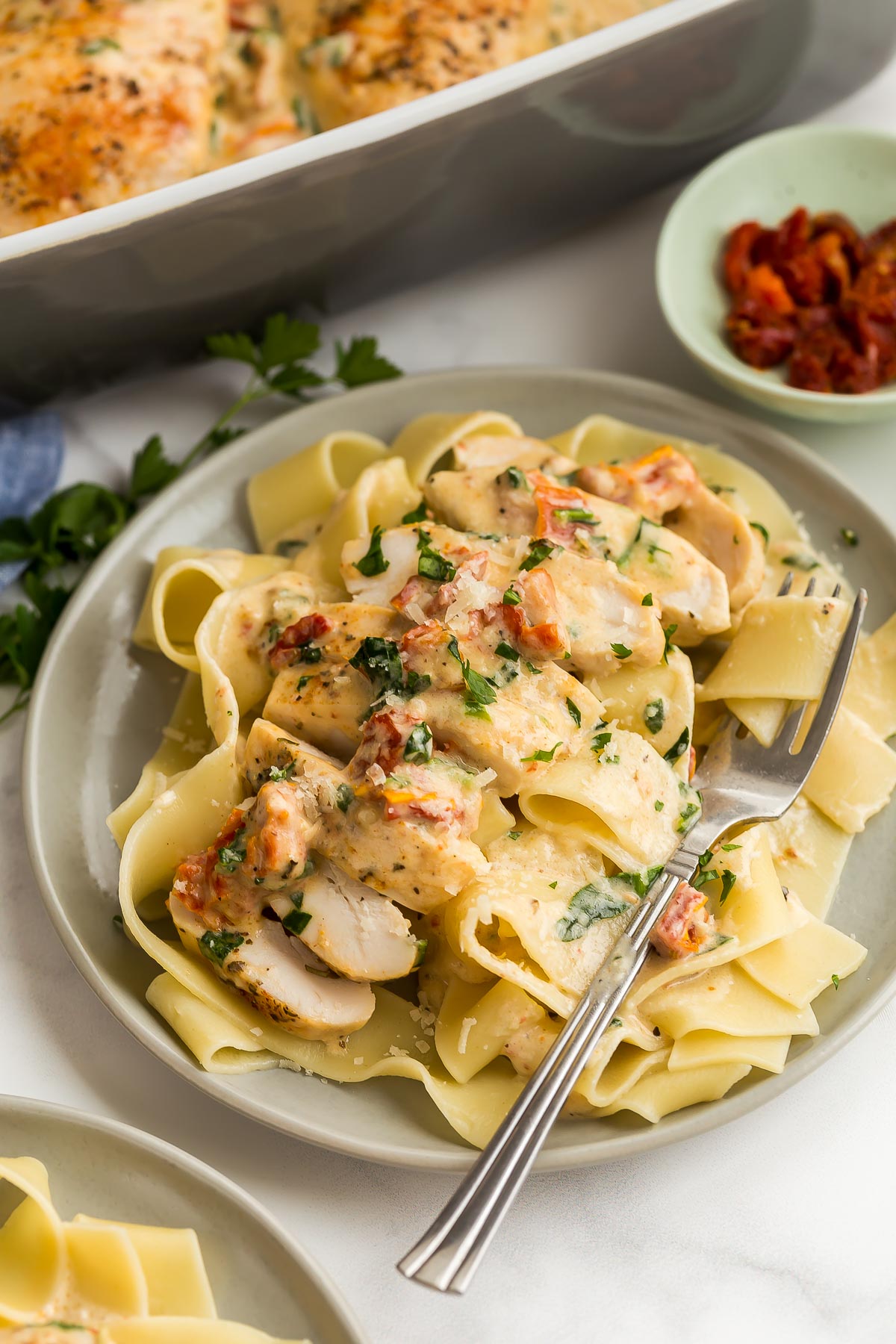 close up image of tuscan chicken on bed of pappardelle.