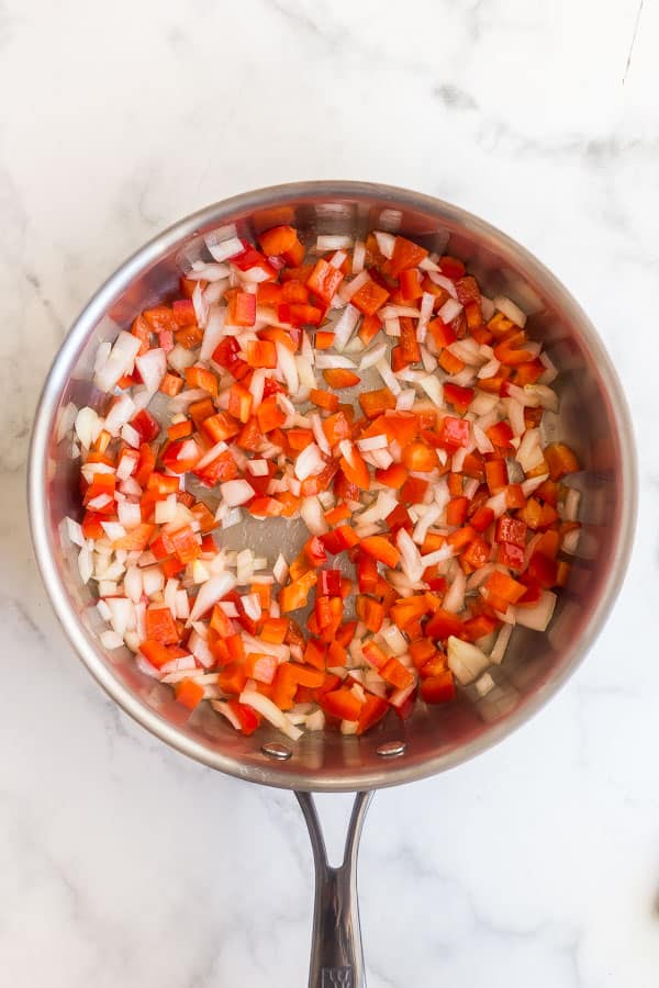 peppers and onions in stainless steel pan