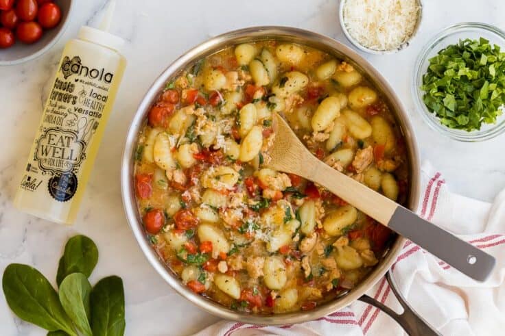 overhead image of gnocchi in pan with bottle of canola oil