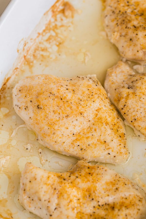 close up image of baked chicken breast in baking dish
