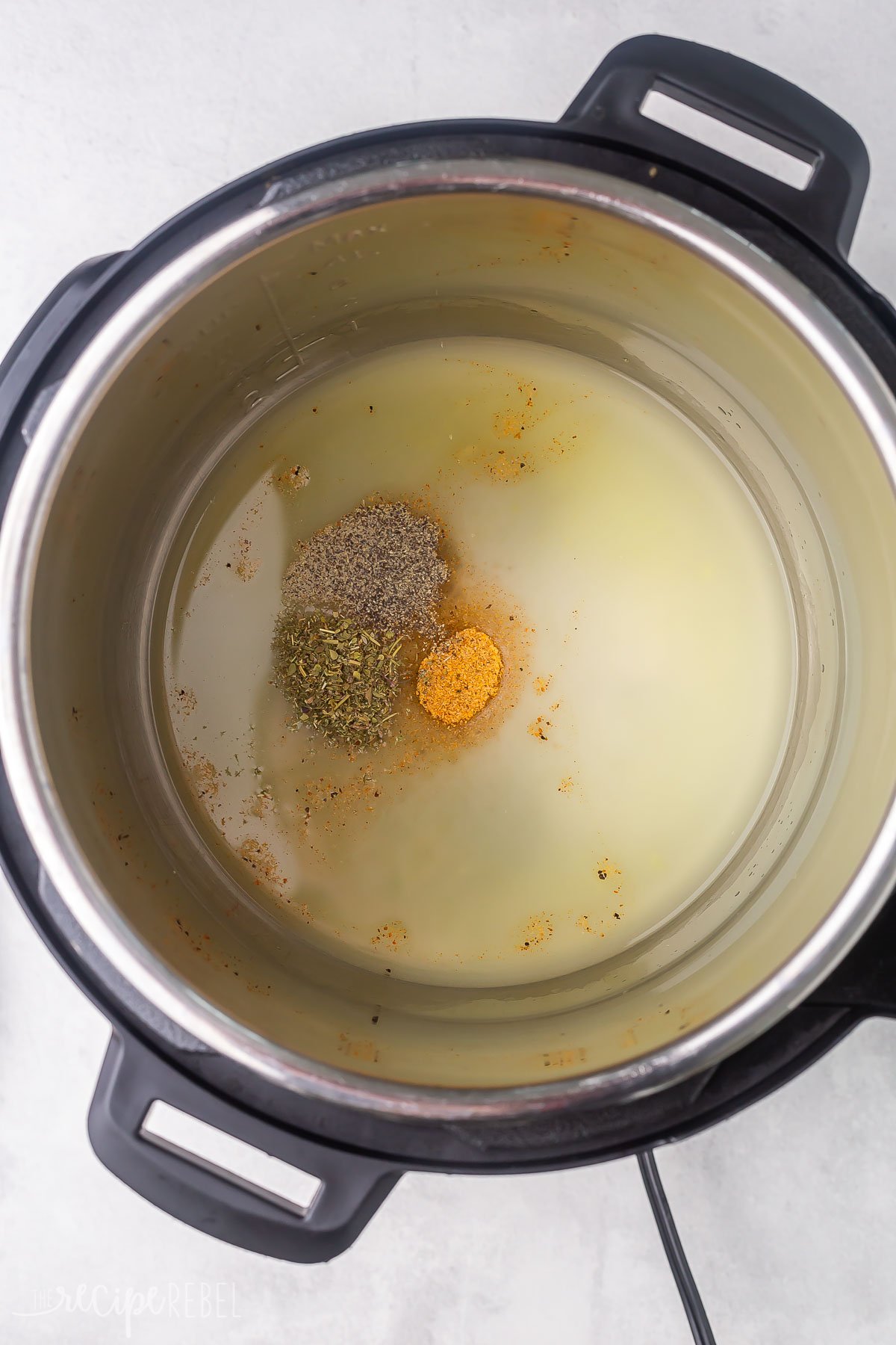 chicken broth and seasonings in pressure cooker.