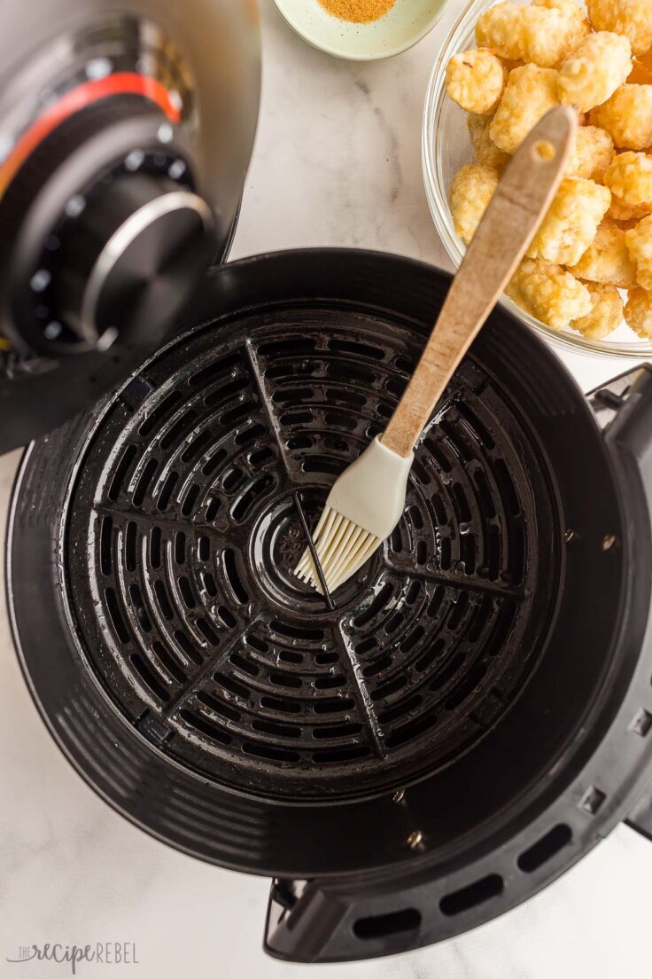 brushing air fryer basket with oil