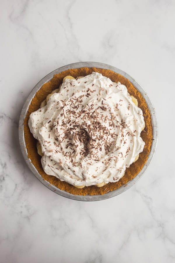 banoffee pie topped with whipped cream and chocolate shavings