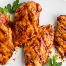 overhead image of grilled bbq chicken on white plate