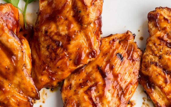 overhead image of grilled bbq chicken on white plate