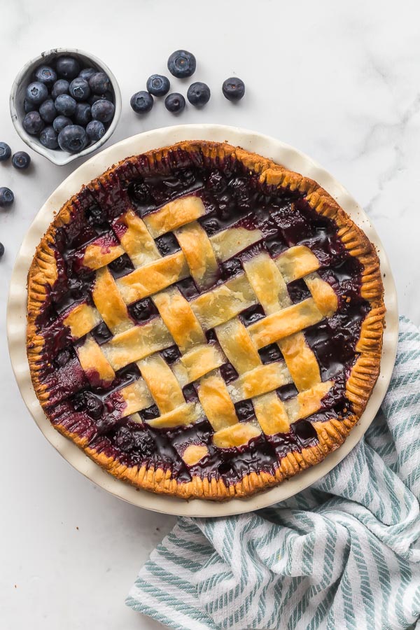 overhead image of baked blueberry pie with fresh blueberries