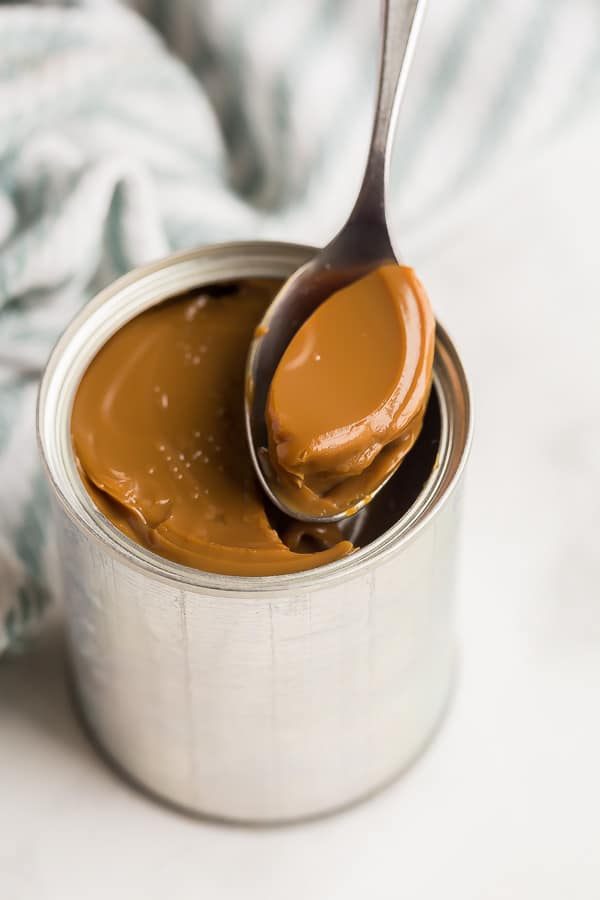 scooping dulce de leche out of can