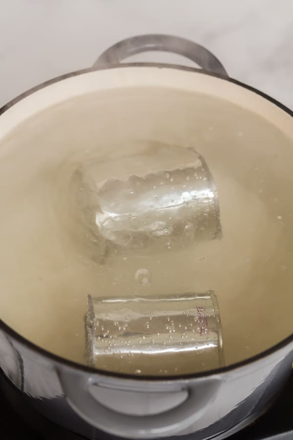 cans of sweetened condensed milk in boiling water