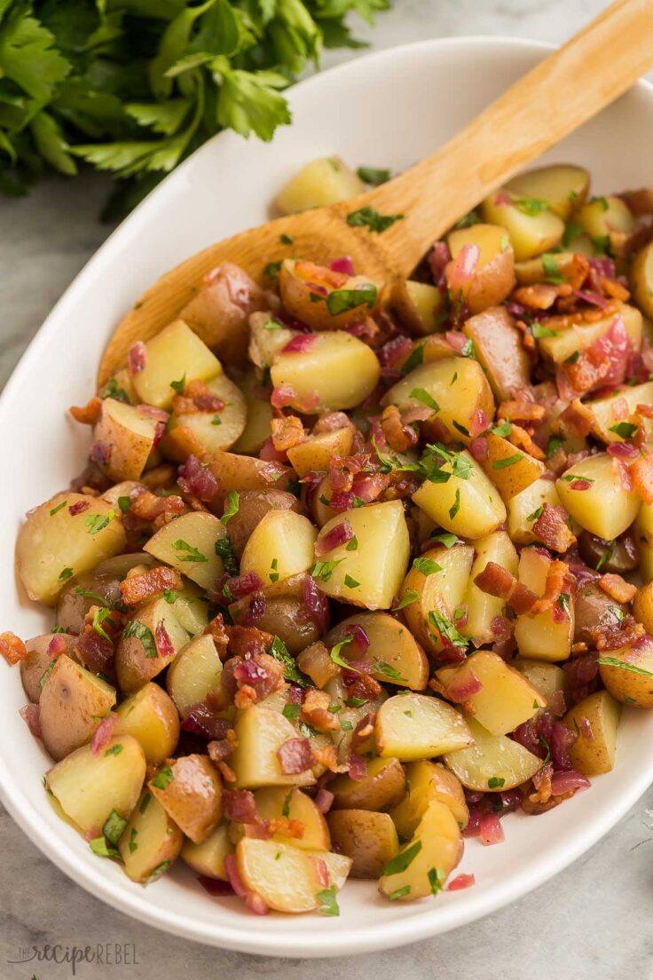 close up image of german potato salad with wooden spoon