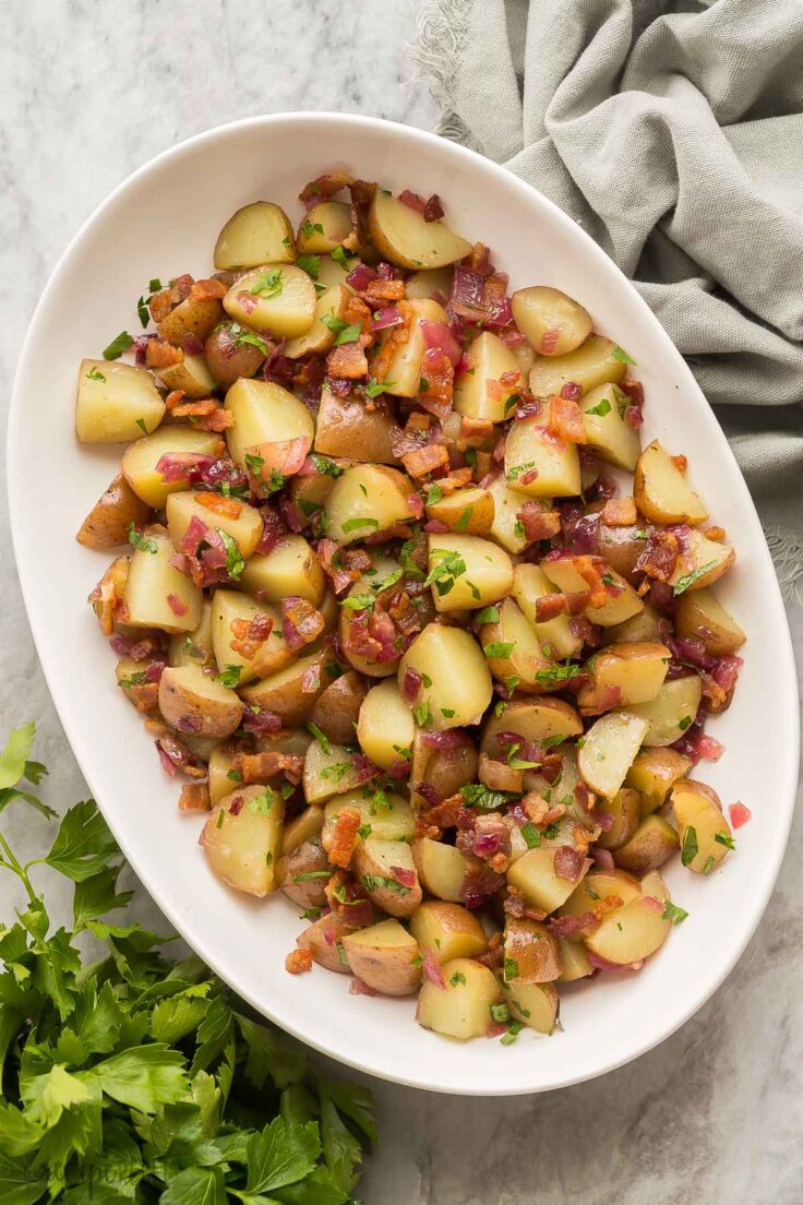 overhead image of german potato salad in white bowl