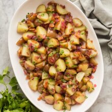 overhead image of german potato salad in white dish with parsley