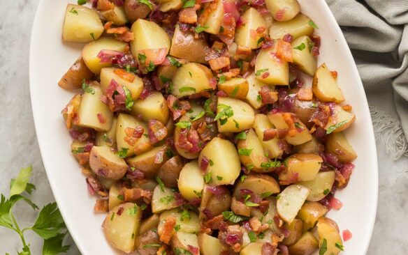 overhead image of german potato salad in white dish with parsley