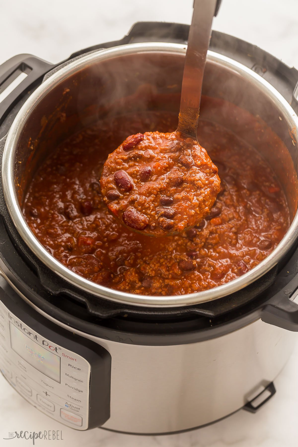 scoop of instant pot chili coming out of pressure cooker
