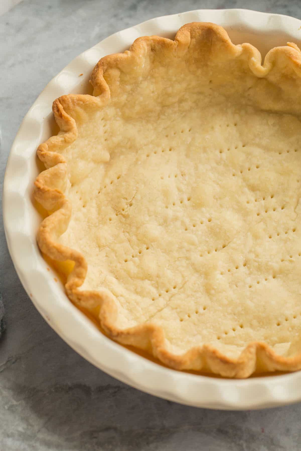 close up image of blind baked pie crust in pie plate.