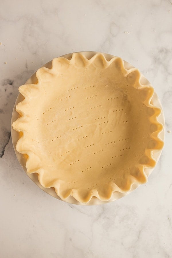 unbaked pie crust with edges crimped