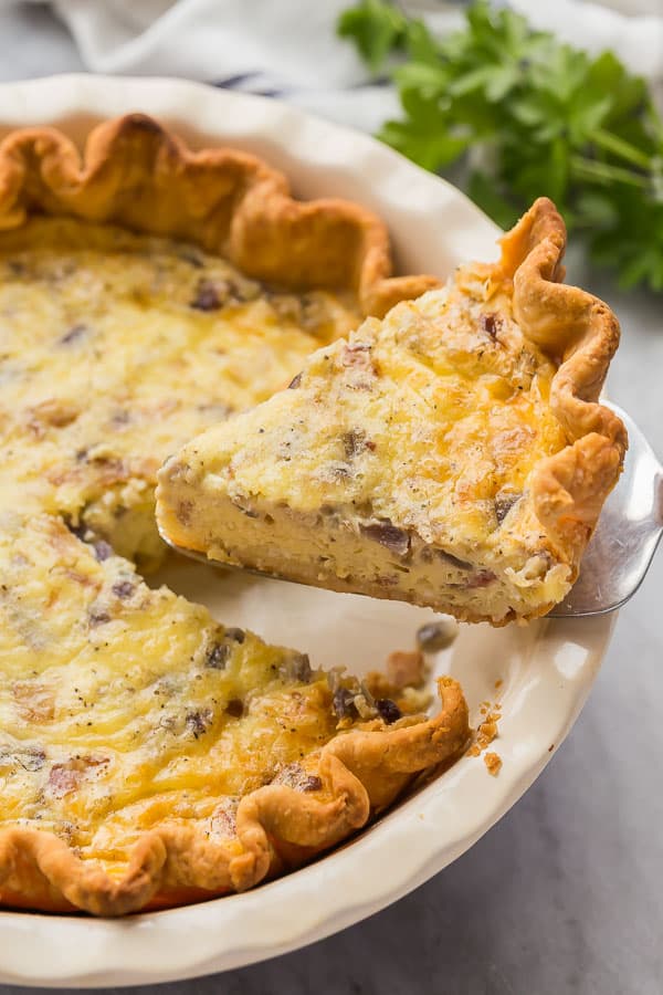 slice of quiche lorraine being lifted out of pie plate