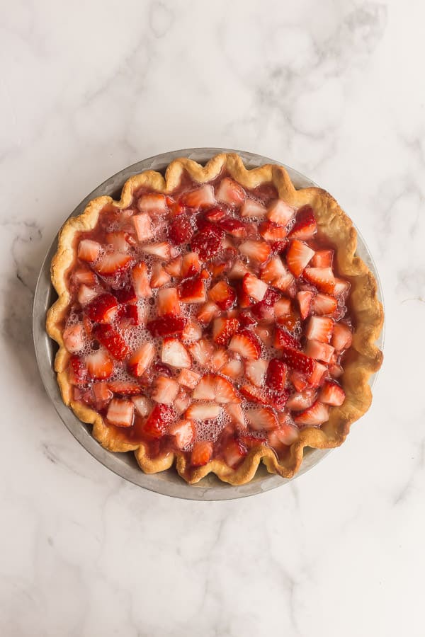 strawberry filling and fresh strawberries in blind baked pie crust