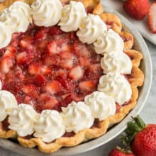 close up image of fresh strawberry pie with whipped cream