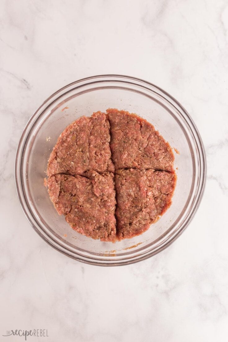 air fryer burger mixture in bowl divided into quarters