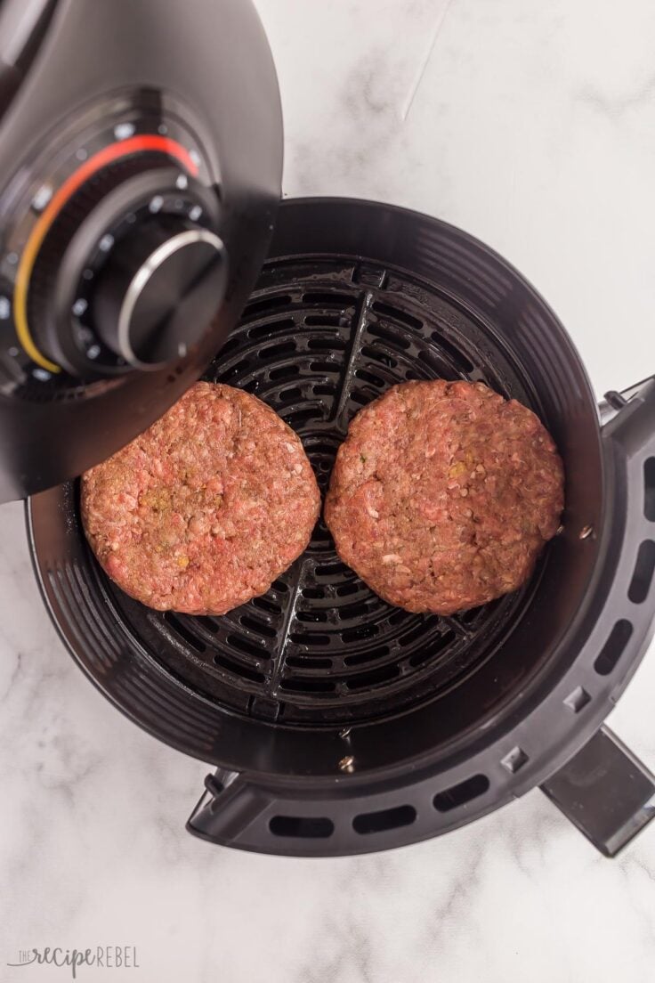 uncooked burgers going into air fryer