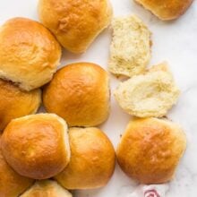 overhead image of brioche buns scattered over white background