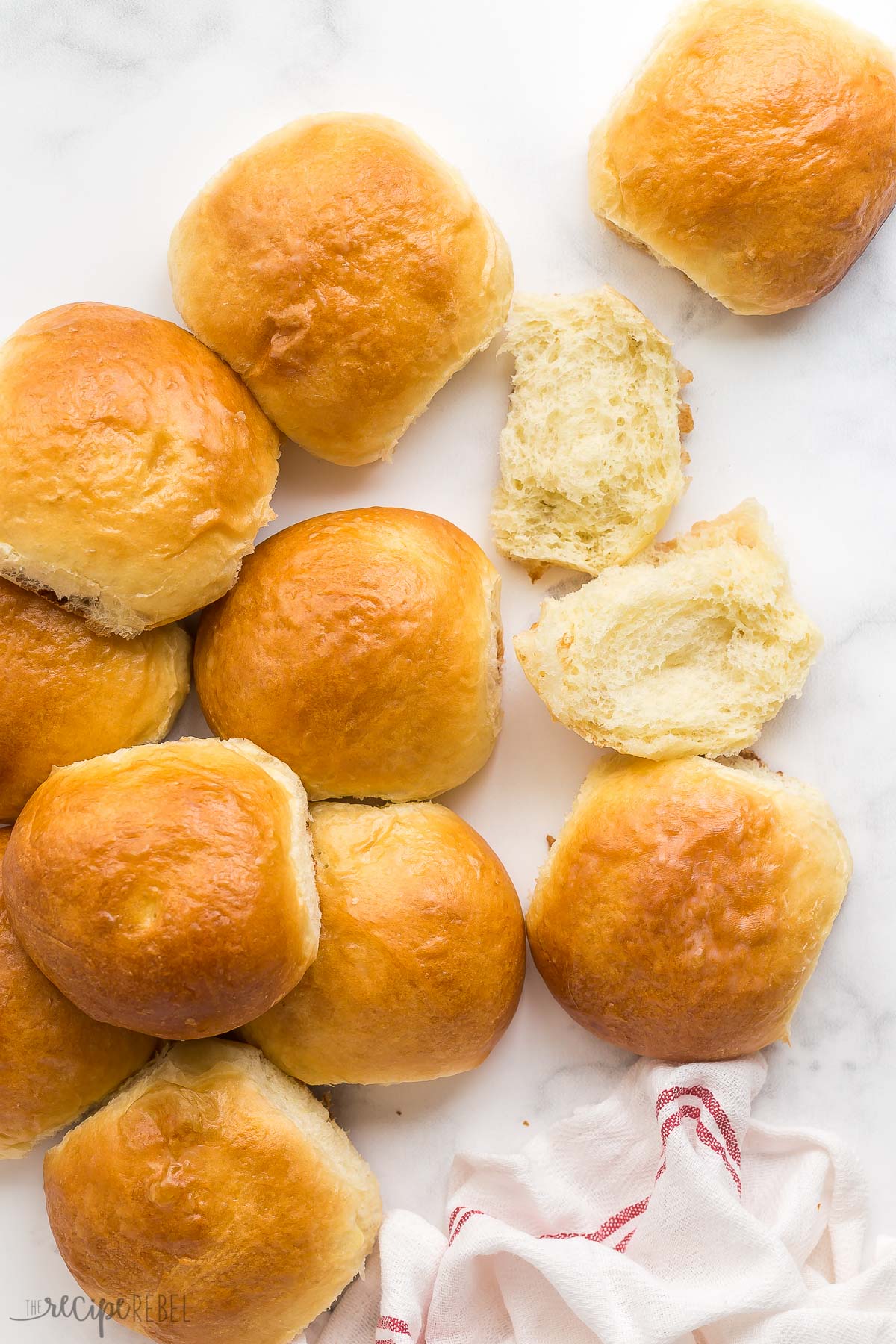 overhead image of brioche buns scattered over white background