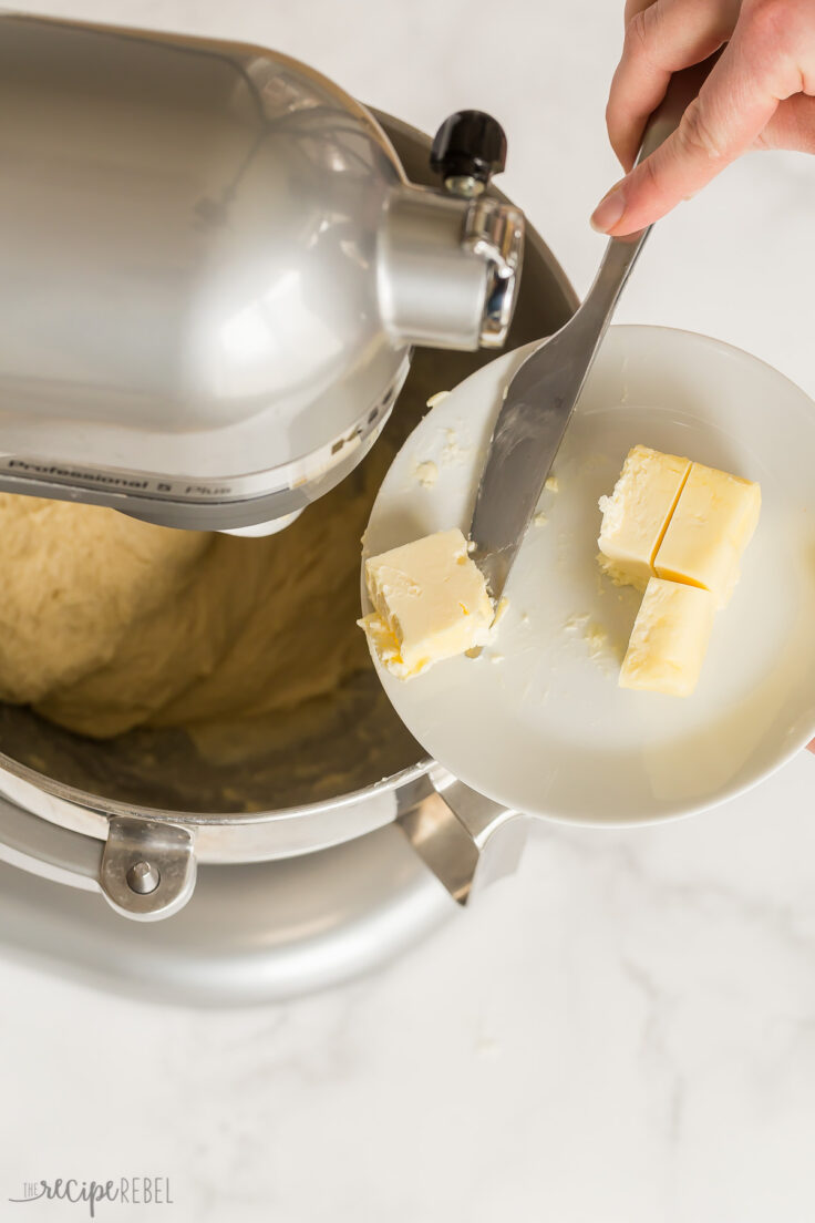 adding butter one tablespoon at a time to brioche bun dough