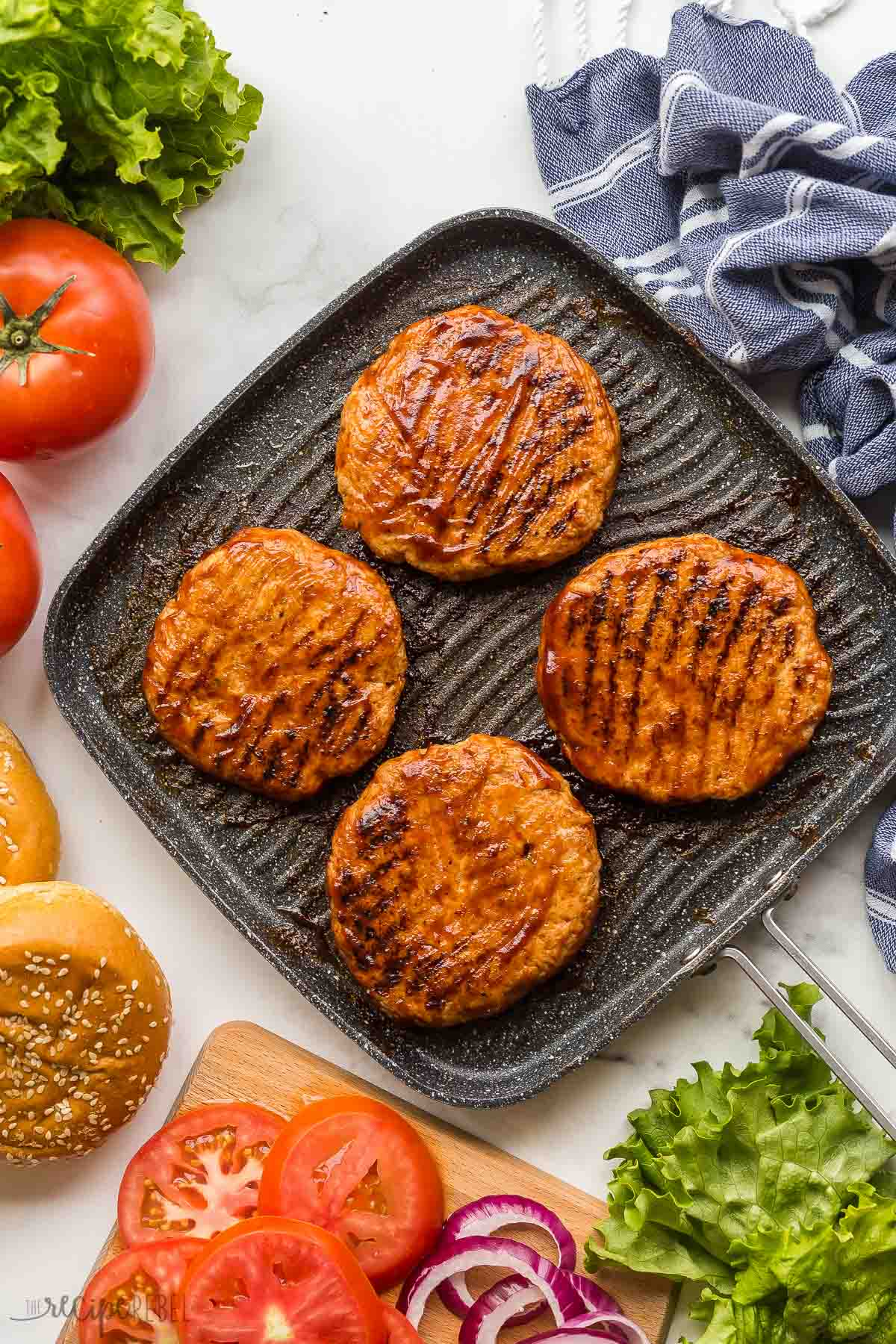 overhead image of grilled chicken burgers in pan