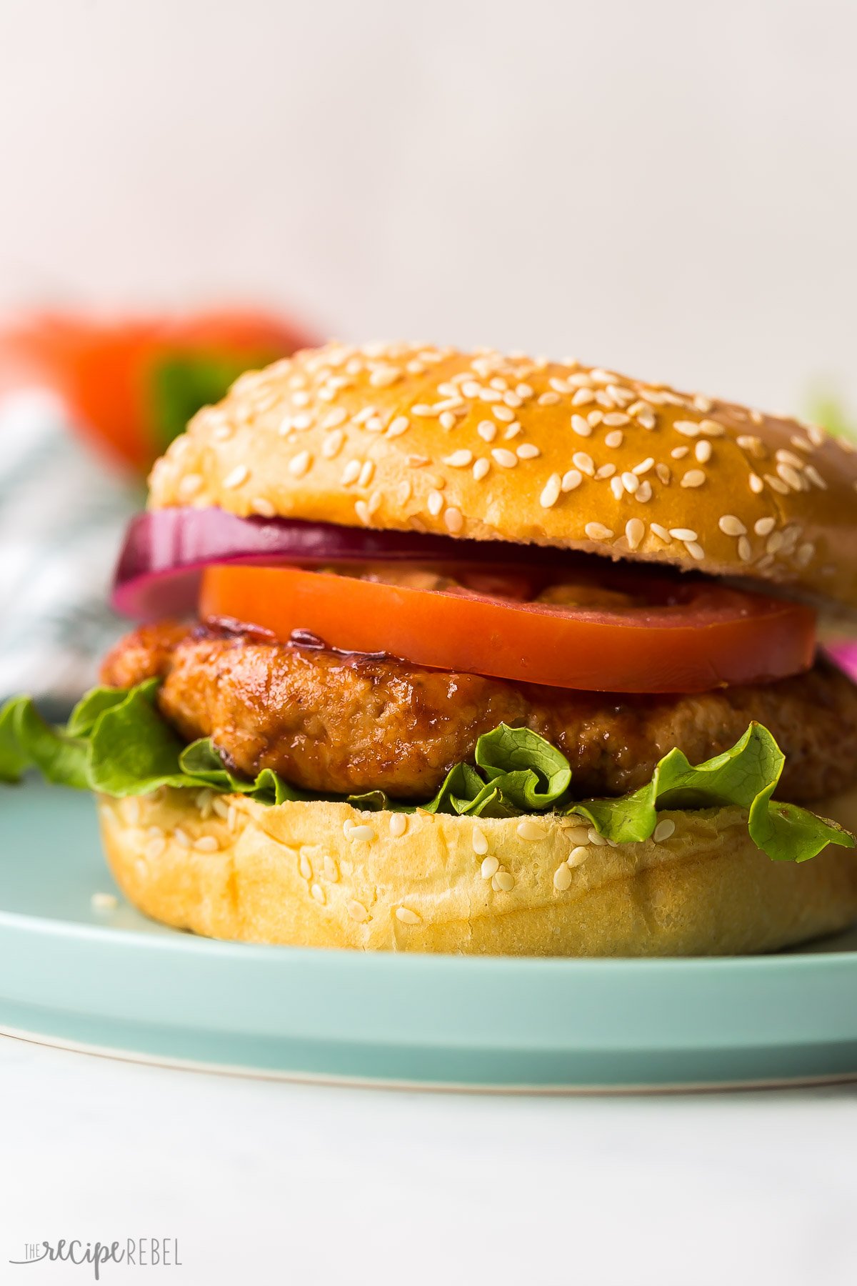 chicken burger on bun with lettuce tomato and onion