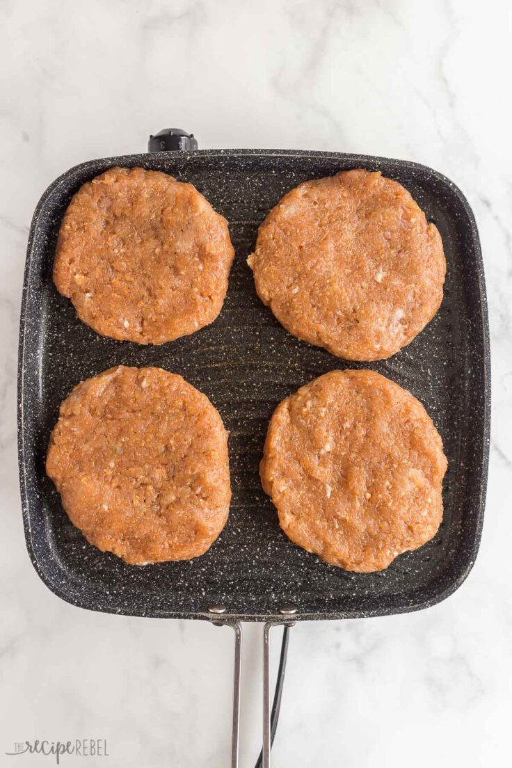 uncooked chicken burgers on grill pan