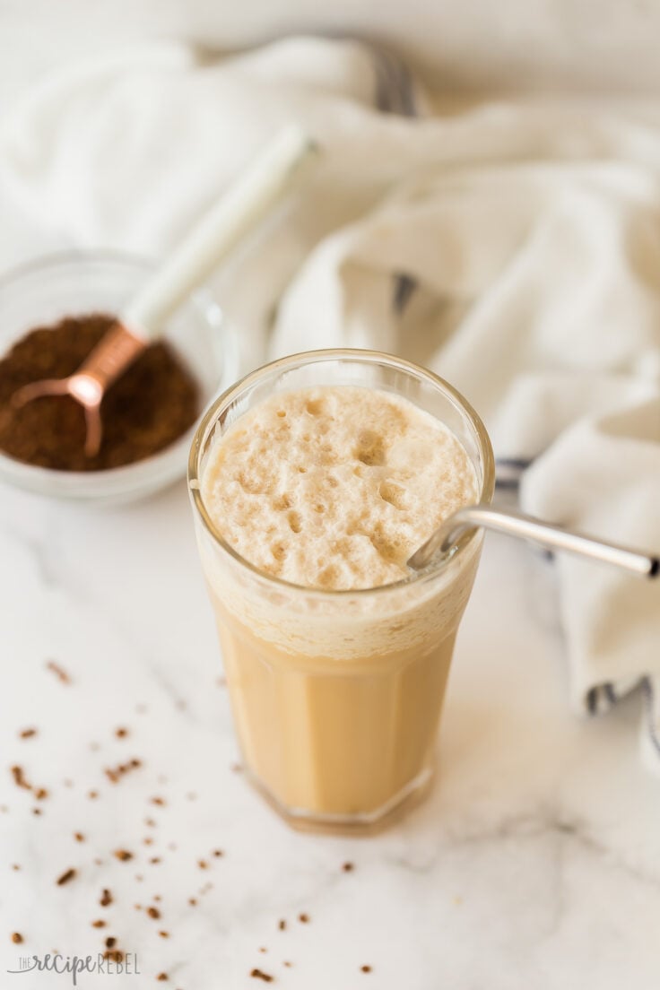 coffee frappe in glass with straw and foam on top