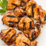 square image of grilled boneless chicken thighs on white plate