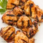 square image of grilled boneless chicken thighs on white plate